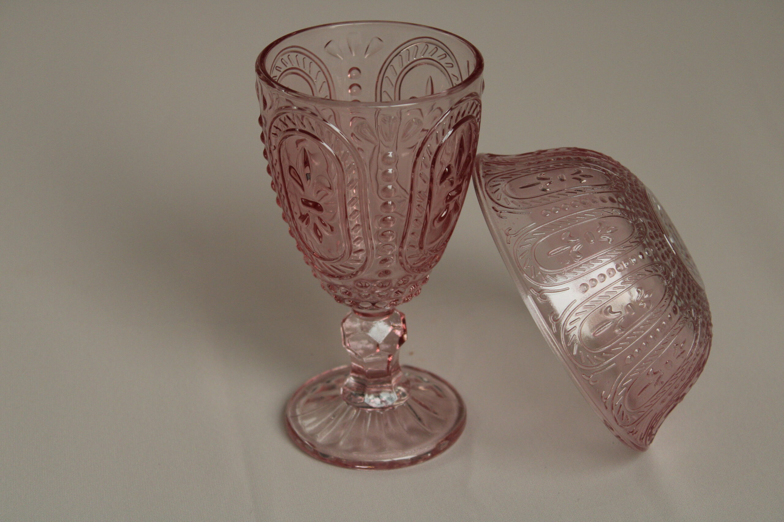 Glazen roze wijnglas en schaaltje